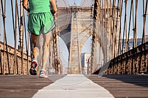 Male marathon runner running over Brooklyn Bridge