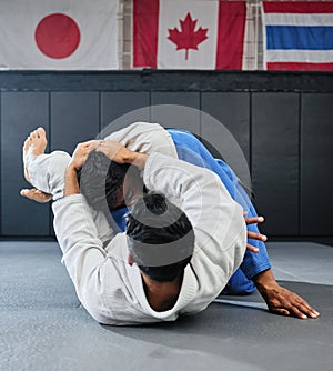 . Male martial arts, fighting at a dojo and holding his opponent. Karate, sports and taekwondo adults training at the