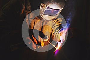 Male in mask welds metal steel, industrial shot photo