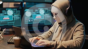 Male masked scammer stealing information from database program