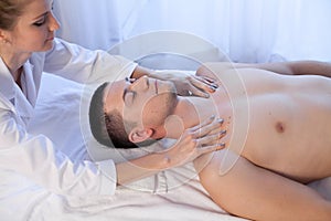 Male masseur doing massage of the face and neck therapy Spa