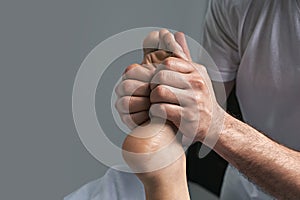 Male masseur hands doing reflexology massage on female foot reflex zones in the spa salon.