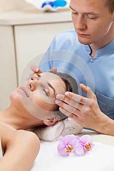 Male masseur massaging female head