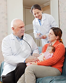 Male mature pediatrician doctor examining newborn baby