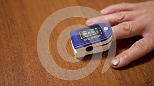 Male Measures Pulse and Oxygen Saturation Using a Pulse Oximeter at Home