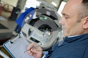 Male mechanic with clipboard in garage