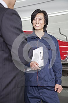 Male Mechanic with Customer in Auto Repair Shop