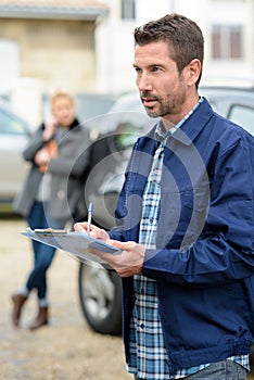 male mechanic examining car outdoors