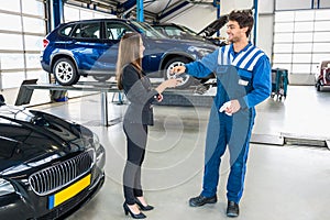Male Mechanic Giving Car Key To Client After Servicing