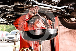 Male mechanic hooking up equipment to the undercarriage of a car