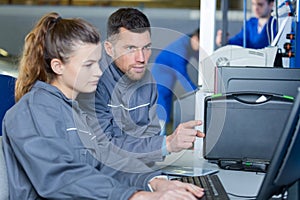 male mechanic teaching diagnostic computerize input to apprentice