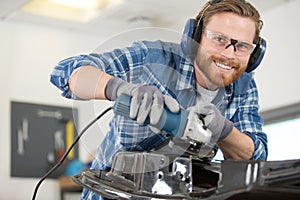 male mechanic using angle grinder
