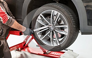 Male mechanic using torque wrench on wheel