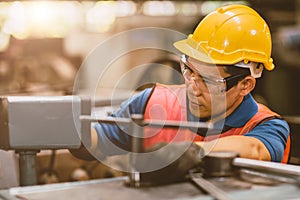 Male mechanic worker with safety helmet working labor in metal industry factory with steel machining