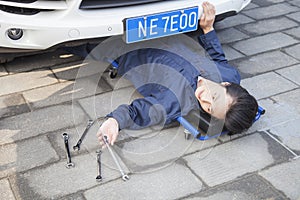 Male Mechanic working under the Car