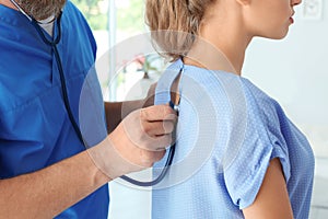 Male medical assistant examining female patient