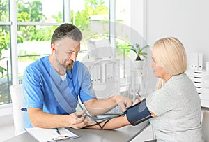 Male medical assistant measuring female patient