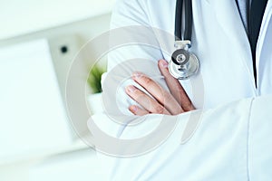 Male medical doctor posing with arms crossed, lab coat, stethoscope and hands close up, healthcare professionals concept
