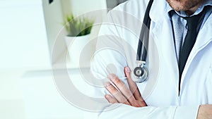 Male medical doctor posing with arms crossed, lab coat, stethoscope and hands close up, healthcare professionals concept