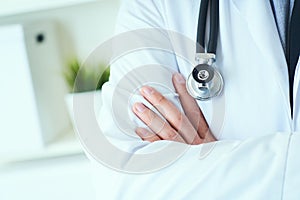 Male medical doctor posing with arms crossed, lab coat, stethoscope and hands close up, healthcare professionals concept