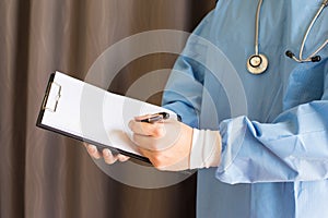 Male medicine doctor hand holding pen writing something on clipboard closeup. Medical care, insurance, prescription, paper work o