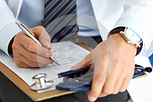Male medicine doctor hand holding silver pen writing