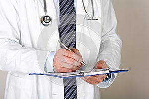 Male medicine doctor hand holding silver pen writing something o