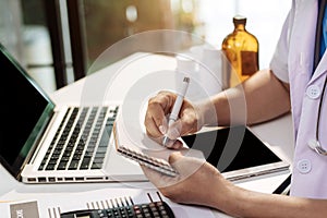 Male medicine doctor, physician or practitioner in lab room writing on notebook.