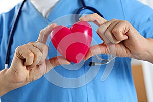 Male medicine doctor wearing blue uniform hold in hands red toy