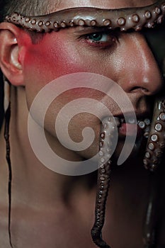 Male model close up portrait with make up and octopus, sea life concept.