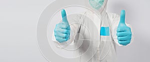 Male model in PPE suite and face mask doing two thumbs up  hand sign on white background