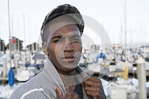 Male model wearing a newsboy cap at the marina