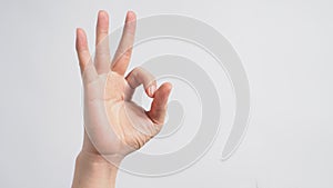 Male moedl is doing A-Ok hand sign on white background