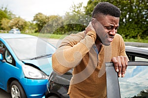 Male Motorist With Whiplash Injury In Car Crash Getting Out Of Vehicle