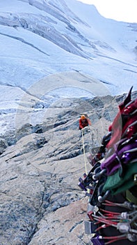 Male mountain climber on an exposed climbing route high above a glacier