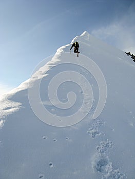 Male mountain climber on his way to a high summit in the Alps after exiting a hard north face climbing route