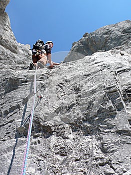 Male mountain climber on a steep rock climbing route in the Swiss Alps near Klosters