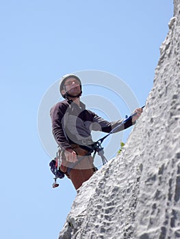 Male mountain climber on a steep rock climbing route in the Swiss Alps near Klosters