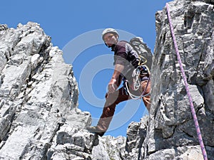 Male mountain climber on a steep rock climbing route in the Swiss Alps near Klosters