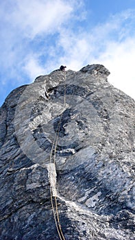 Male mountain climber on a steep rock climbing route in the Swiss Alps near Klosters