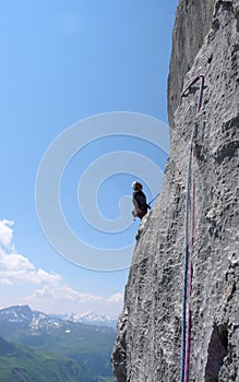 Male mountain climber on a steep rock climbing route in the Swiss Alps near Klosters