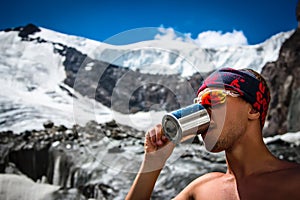 Male mountaineer drinking water from a mug on a glacier in the mountains Travel Lifestyle concept adventure active vacations extre