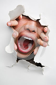 Male mouth screaming from cracked wall