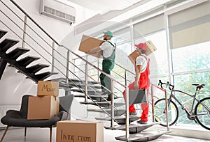 Male movers carrying boxes