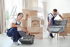 Male movers with instruments and armchair photo