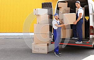 Male movers unloading boxes from van