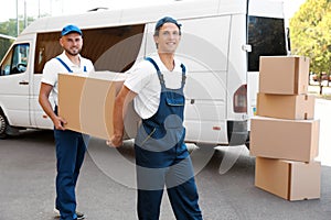 Male movers unloading boxes from van