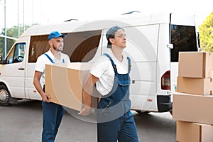 Male movers unloading boxes from van