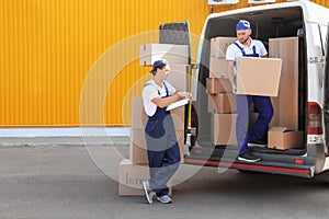 Male movers unloading boxes from van