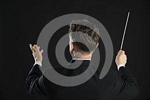 Male Music Conductor Directing With His Baton photo